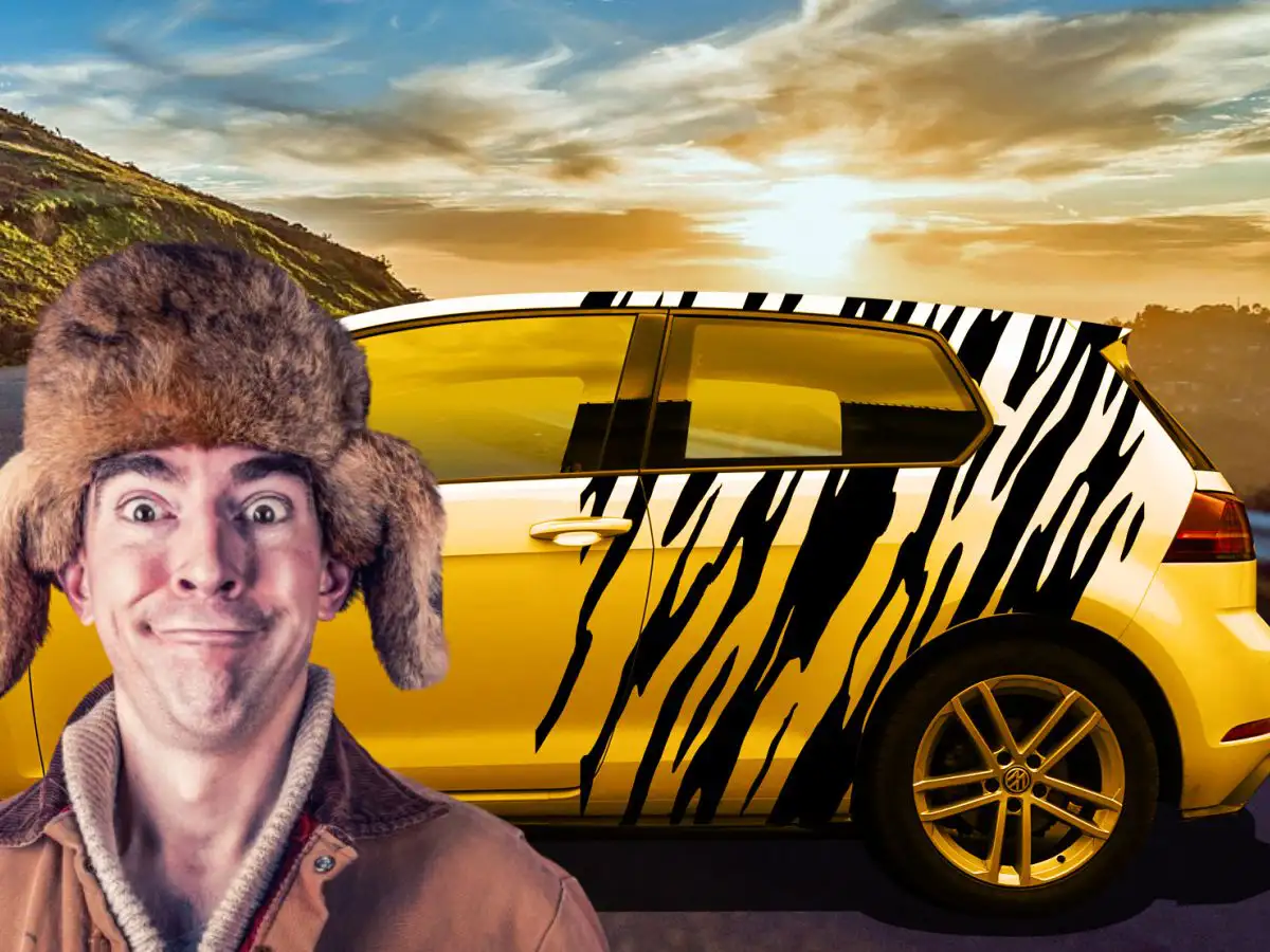 Freundlicher Mann mit Pelzmütze vor seinem gelben VW Golf im Camouflage-Style in Schwarz