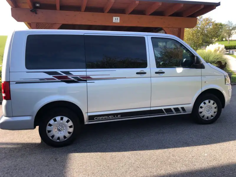 Kunden-Referenzbild - silberner VW T6 mit dem Motiv T6 Bus Autodesign in Schwarz und Dunkelrot vor Carport in Österreich - Foto Manfred Pühringer
